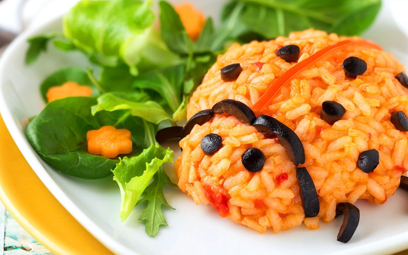 Kindgerecht angerichtetes Menü mit Reis, Oliven und Salat
